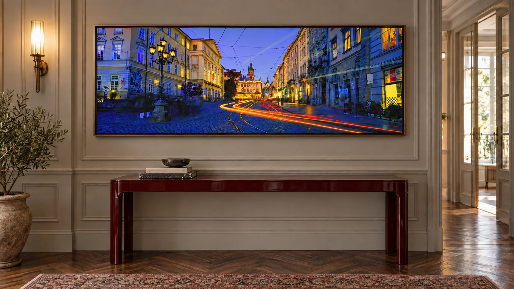 Illustrative mockup of the evening street panorama in a bronze frame above an oxblood console in a panelled hallway with parquet flooring.