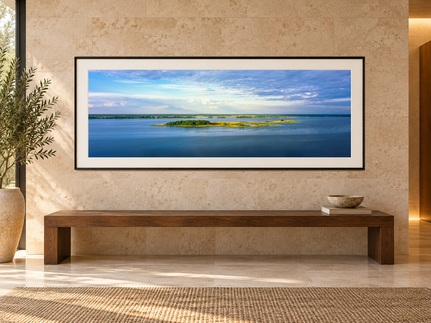 Illustrative interior mockup: original Islands of Light panorama in a black frame with an off-white mat above a dark-oak bench against a limestone wall.