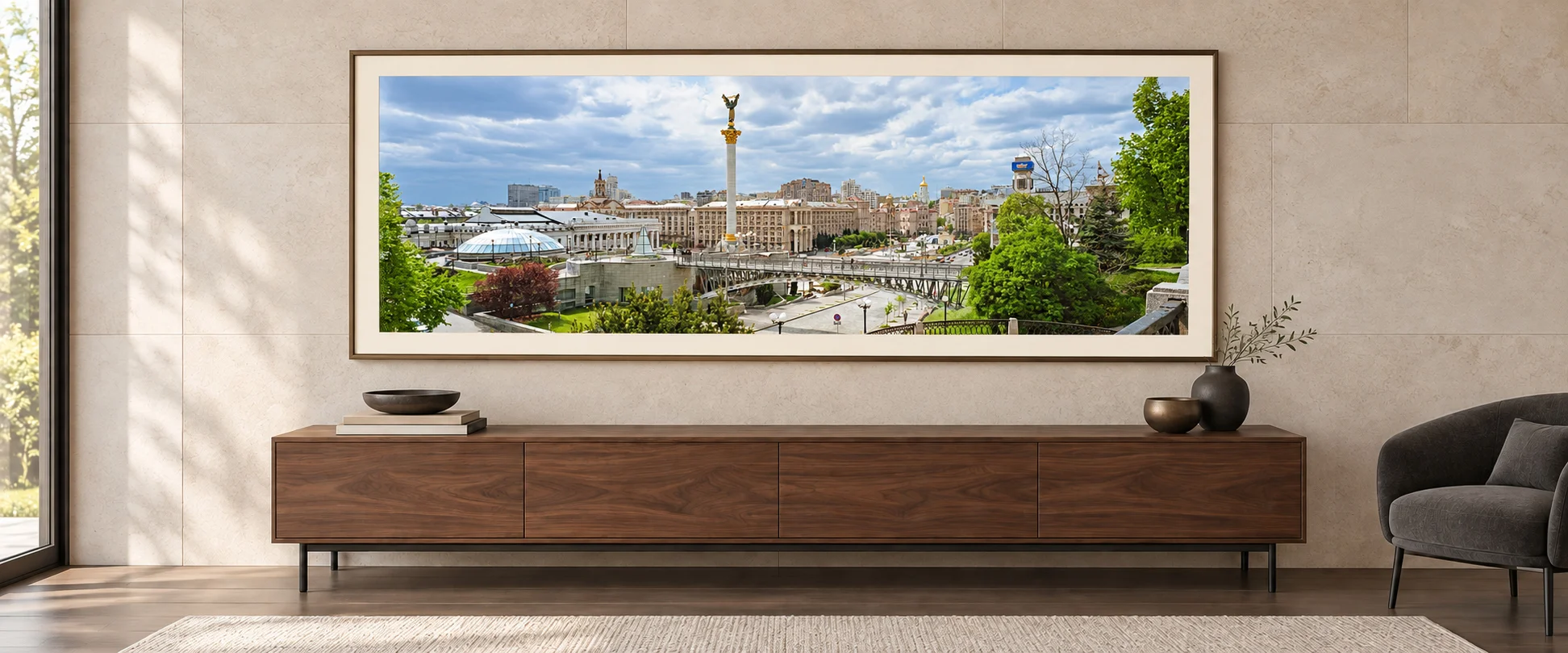 Illustrative mockup of the Kyiv panorama with an ivory mat and bronze frame above a walnut console in a pale limestone architectural study.