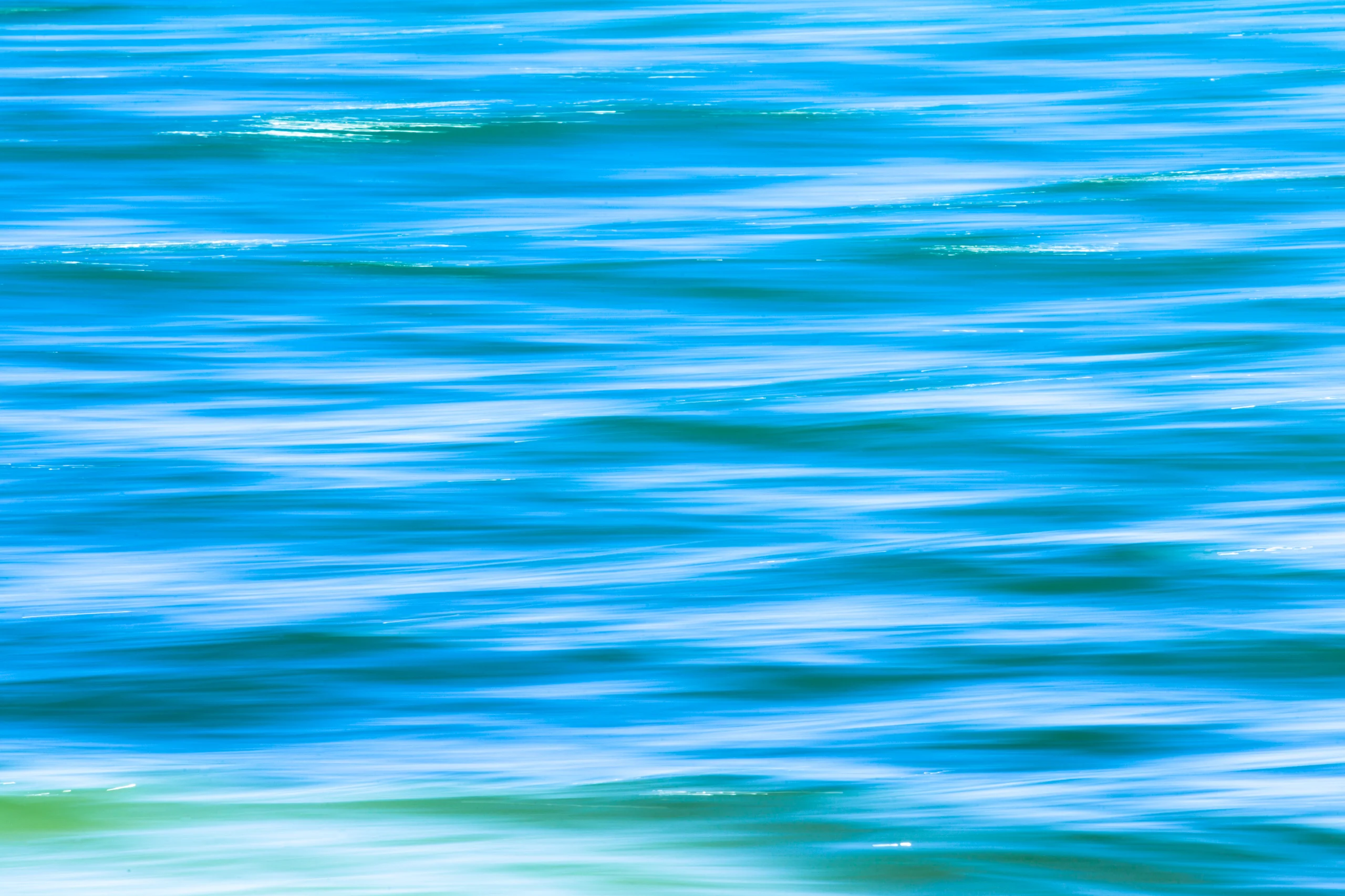 Abstract blue and turquoise water with flowing white reflections and soft green bands.